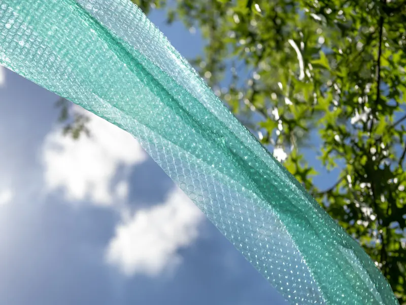 Green Ocean Green® bubble wrap against a blue sky and trees